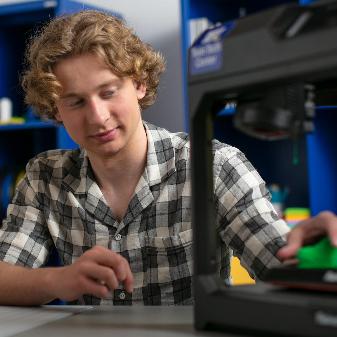 teen is using a 3d printer to build something