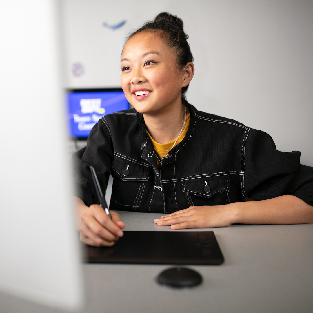 teen uses a drawing tablet at a computer