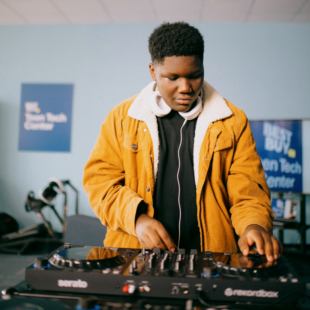 teen is mixing music in front of a full dj setup